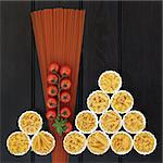 Tomato  spaghetti and italian pasta dried food selection in porcelain crinkle bowls over dark wood  background.