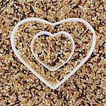 Healthy seven grain and cereal food mixture in heart shaped bowls and forming an abstract background.