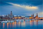 Image of Dresden, Germany during twilight blue hour with Elbe River in the foreground.