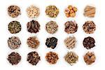 Large chinese herbal medicine selection in china bowls over white background.