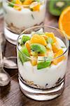 Yogurt with muesli, kiwi and orange in a glass