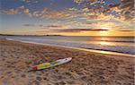 Beach sunrise and paddleboard on the sand  at shoreline.