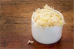 sauerkraut side dish - a white tasting bowl against rustic wood