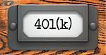 Inscription 401K on File Drawer Label on a Wooden Background.