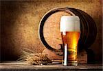 Wooden barrel and beer with wheat on a wooden table