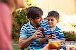 Father and son toasting in garden