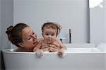 Mother and baby girl in bathtub