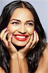 Female model smiling, face resting on hands