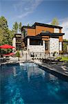 Beige stone and wood modern house with garden swimming pool