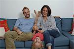 Parents with son sitting on sofa