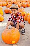 Portrait of boy choosing pumpkin in farmyard
