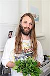 Portrait of smiling young man holding greens