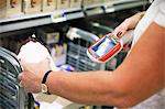 Woman using barcode reader in shop