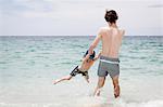 Father playing with son on beach