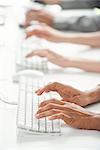 Office workers using computer keyboards, cropped