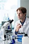 Scientist working in laboratory, looking away in thought