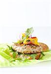 Pork burger with peach and arugula on a lime green napkin, studio shot on white background