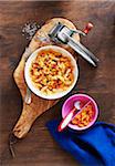 Rotini Pasta with sweet potato sauce on a wooden cutting board with cheese grater, studio shot