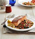 Seared Salmon with grain pilaf and lemons on a plate, studio shot