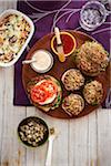 Vegetarian burgers on a platter with side dishes, studio shot