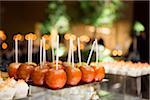 Close-up of dessert platters with glazed apples on sticks, at an event, Canada
