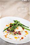 Close-up of black cod fish filet with a Chinese sausage and rice side dish and green beans on a dinner plate, at an event, Canada