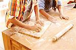 Children making dough in kitchen