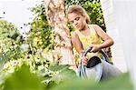 Girl concentrating whilst watering plants in garden