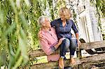 Husband carrying wife onto garden fence