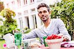 Mid adult man sitting at table in garden