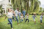 Three generational family running in garden