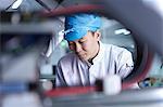 Worker using machinery in factory that specialises in creating functional circuits on flexible surfaces