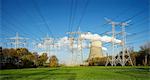 Rows of electrical towers in front of cooling tower and smoke stacks