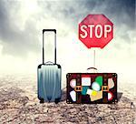 Travel suitcase over desert landscape background with cracked ground.