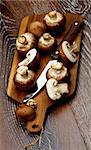 Gourmet Raw Portabello Mushrooms Full Body and Halves with Table Knife on Cutting Board closeup on Dark Wooden background