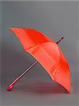 opened red umbrella isolated on gray background