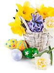 Easter eggs with spring flowers in basket. Isolated on white background