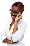 African female executive adjusting her spectacle. Looking at camera and smiling