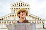 Happy young woman with map in front of duomo di pisa, pisa, tuscany, italy