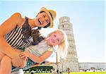 Portrait of mother and baby girl in front of leaning tower of pisa, tuscany, italy