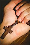 Hand holding wooden rosary beads in close up