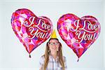 Geeky hipster holding balloons on white background