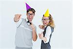 Happy geeky hipster couple dancing with party hat on white background
