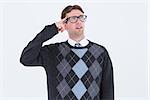 Geeky hipster thinking with finger on temple on white background