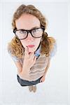 Geeky hipster woman thinking with hand on chin on white background