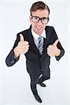 Geeky hipster smiling at camera with thumbs up on white background