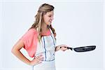 Happy hipster woman holding frying pan on white background