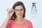 Hipster with eyeglasses and eyes test behind her on white background