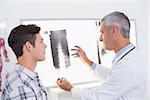 Doctor looking at X rays with his patient in medical office