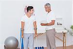 Man with crutch speaking with his doctor in medical office